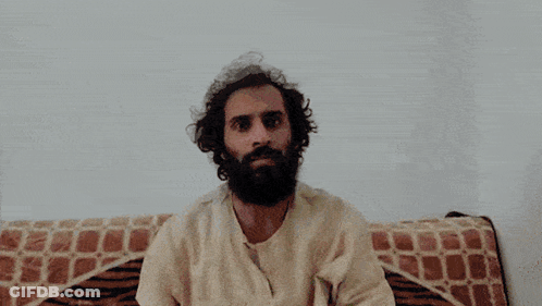 Man With Beard Sitting On Couch With Blanket On Head GIF
