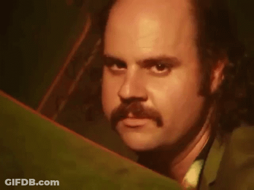 Man With Beard Sitting On Green Couch GIF