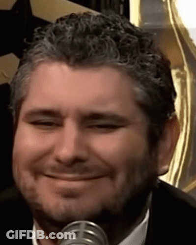 Man With Beard Smiling At Microphone In Suit And Tie GIF