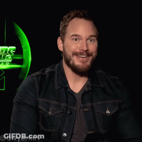 Man With Beard Smiling In Front Of Green Star Wars Logo GIF