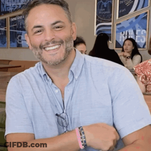Man With Beard Smiling In Front Of United States Sign GIF