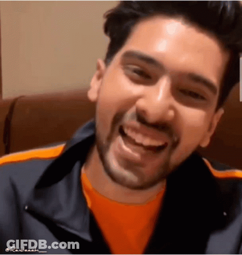Man With Beard Smiling In Orange Shirt And Black Jacket GIF