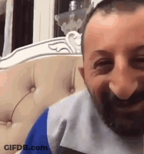 Man With Beard Smiling On Couch GIF