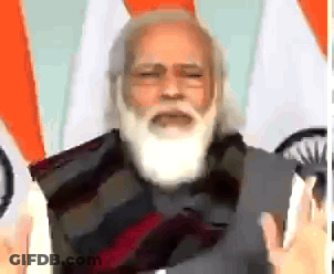 Man With Beard Speaking In Front Of Flags GIF