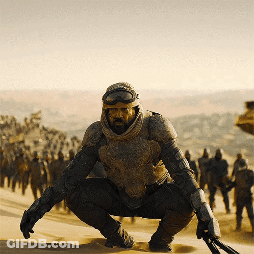 Man With Beard Squatting In Desert GIF