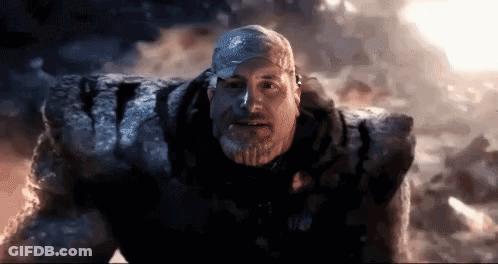 Man With Beard Standing Before Giant Rock GIF