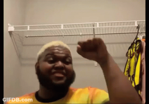 Man With Beard Standing In Closet Fist Up GIF
