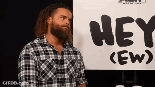 Man With Beard Standing In Front Of Sign Saying Hey GIF