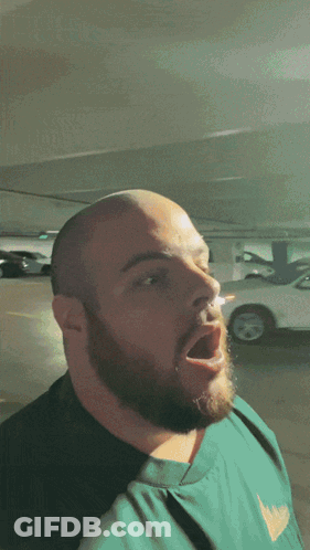 Man With Beard Standing In Parking Lot Mouth Open GIF