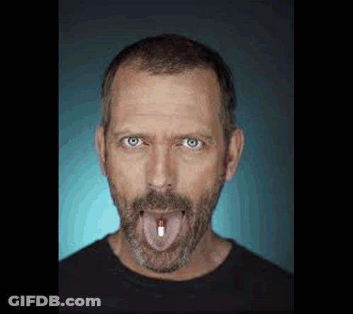 Man With Beard Sticking Out Tongue Holding Pill GIF