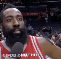 Man With Beard Talking Into Microphone In Stadium GIF