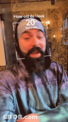 Man With Beard Wearing Headband That Says How Old Do I Look GIF