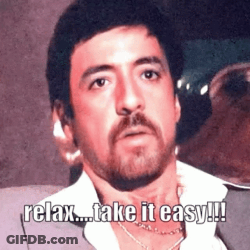 Man With Beard Wearing Suit And Necklace Says Relax GIF