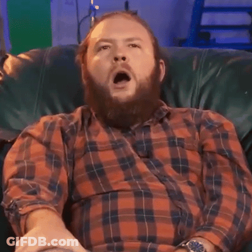 Man With Beard Yawning In Plaid Shirt GIF