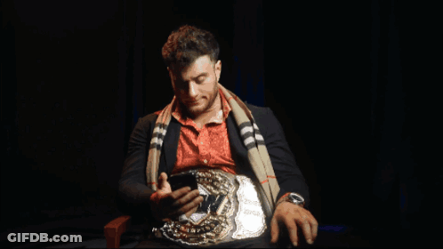 Man With Belt Holding Phone GIF