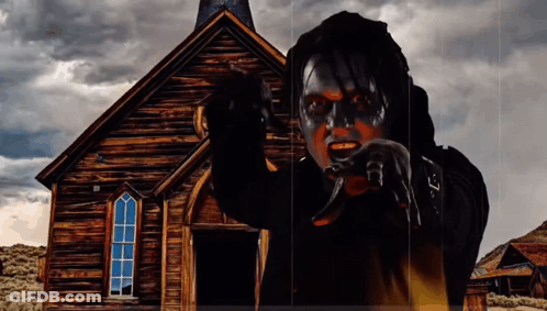 Man With Black Paint On Face In Front Of Old Wooden Church GIF