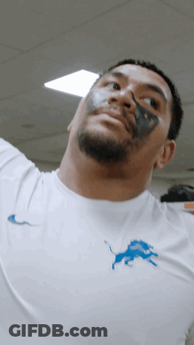 Man With Black Paint On Face In White Shirt With Blue Lion GIF