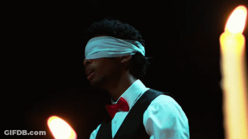 Man With Blindfold In Front Of Candles GIF