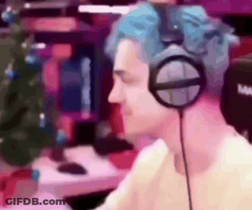 Man With Blue Hair Wearing Headphones In Front Of Christmas Tree GIF
