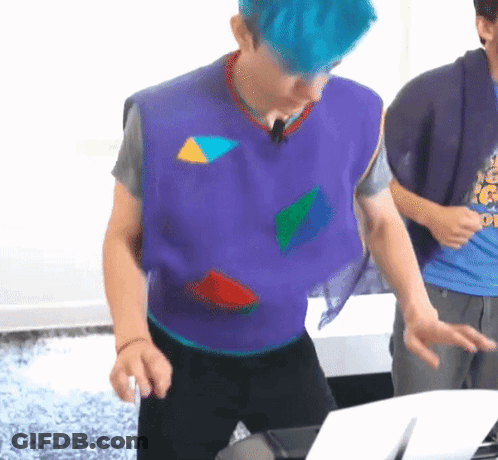 Man With Blue Hair Wearing Purple Vest With Geometric Shapes GIF