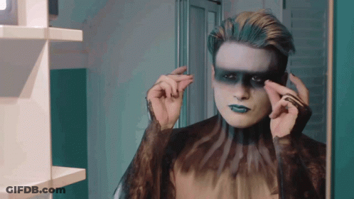 Man With Blue Makeup Looking In Mirror GIF