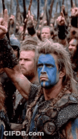 Man With Blue Paint On Face In Front Of Crowd GIF