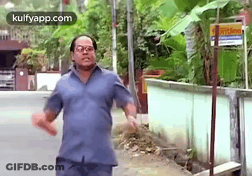 Man With Blue Shirt And Glasses Walking Street GIF