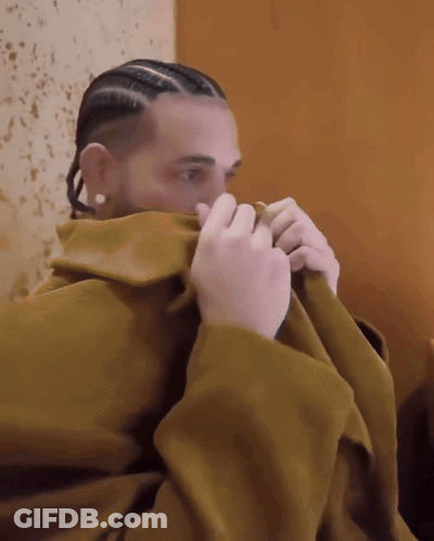 Man With Braids And Earrings Covering Face With Blanket GIF