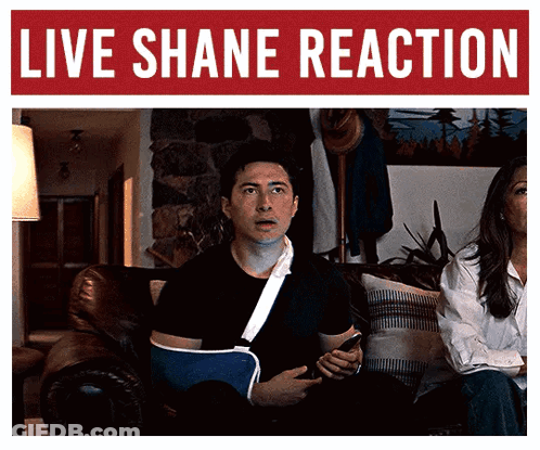 Man With Broken Arm Sitting Under Shane Reaction Banner GIF