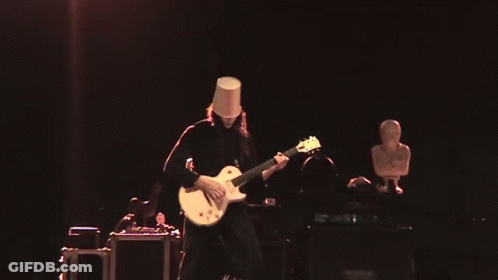 Man With Bucket On Head Playing Guitar On Stage GIF
