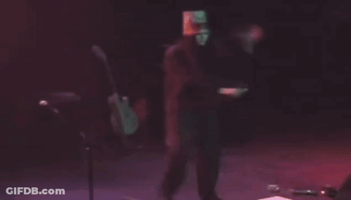 Man With Bucket On Head Playing Guitar On Stage GIF