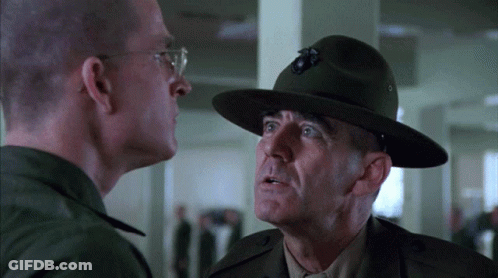 Man With Bug Hat Talks To Man In Military Uniform GIF