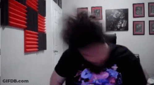 Man With Bun Sitting In Chair By Pictures GIF