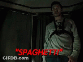 Man With Camera Around Neck In Dark Room With Spaghetti In Red GIF