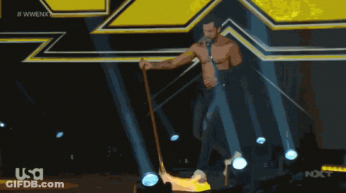 Man With Cane On Stage In Front Of WWE Logo GIF