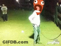 Man With Cartoon Face On Head Standing In Field At Night GIF