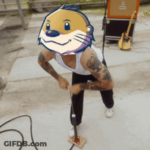 Man With Cartoon Otter On Head At Microphone GIF