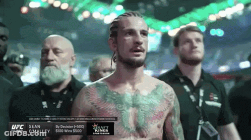 Man With Chest Tattoo And Other Men In Boxing Ring GIF