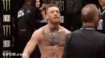 Man With Chest Tattoo Next To Man In Black Suit GIF