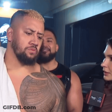 Man With Chest Tattoo Talking To Woman At Microphone GIF
