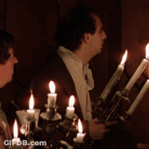 Man With Cigarette In Front Of Candle Holder GIF