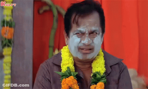 Man With Clay Mask And Flower Garland Making Funny Face GIF