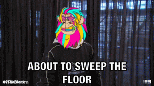 Man With Colorful Monkey On Head About To Sweep Floor GIF