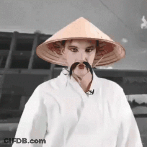 Man With Conical Hat And Mustache In White Robe GIF