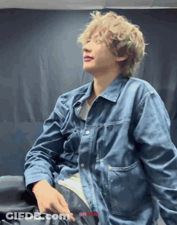 Man With Curly Blonde Hair In Blue Jacket GIF