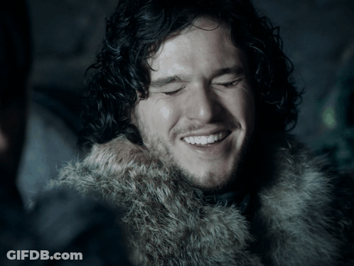 Man With Curly Hair And Beard In Fur Coat Smiles GIF