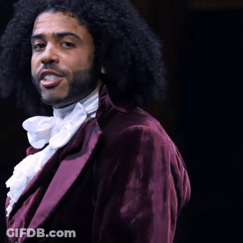 Man With Curly Hair And Beard In Purple Jacket And White Tie GIF