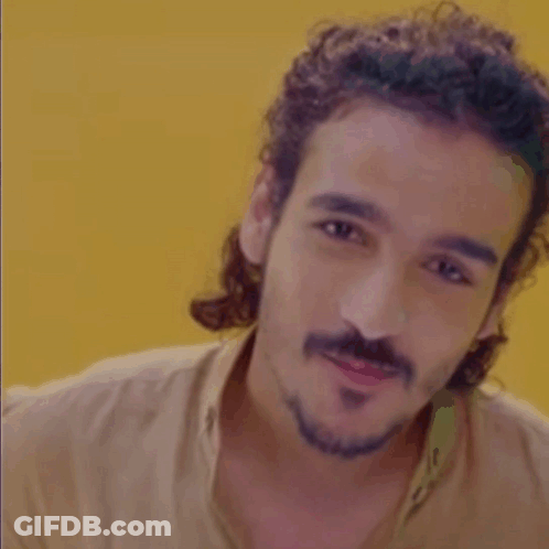 Man With Curly Hair And Beard In Tan Shirt GIF