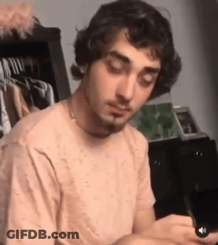 Man With Curly Hair And Beard Looking At Cell Phone GIF