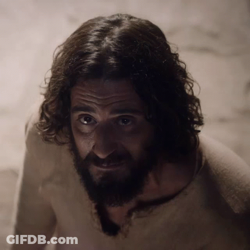 Man With Curly Hair And Beard Looks At Camera GIF